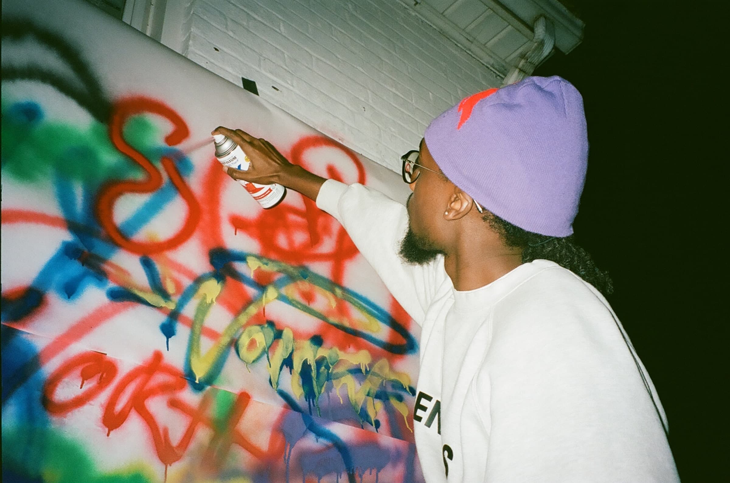 A guest adding blue paint to Tag-A-Wall.