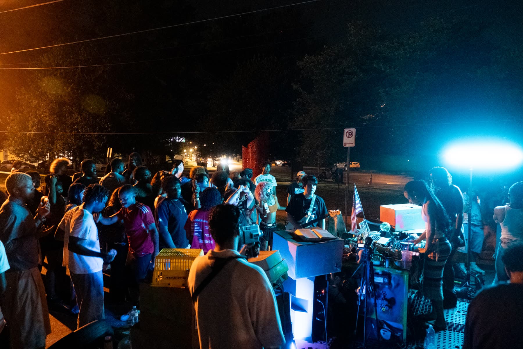 A crowd gathered around the Off The Record DJ booth at night.