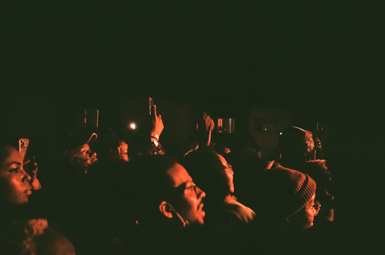 A crowd watching a performance in warm stage light.